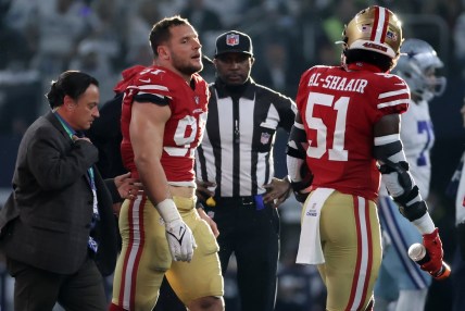 Jan 16, 2022; Arlington, Texas, USA; San Francisco 49ers defensive end Nick Bosa (97) walks off the field with team medical staff after an operant injury during the first half of the NFC Wild Card playoff football game against the San Francisco 49ers at AT&T Stadium. Mandatory Credit: Kevin Jairaj-USA TODAY Sports
