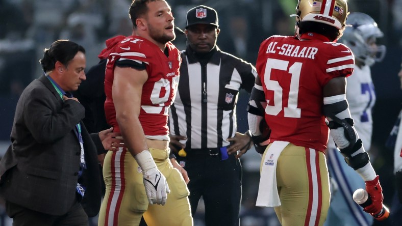 Jan 16, 2022; Arlington, Texas, USA; San Francisco 49ers defensive end Nick Bosa (97) walks off the field with team medical staff after an operant injury during the first half of the NFC Wild Card playoff football game against the San Francisco 49ers at AT&T Stadium. Mandatory Credit: Kevin Jairaj-USA TODAY Sports