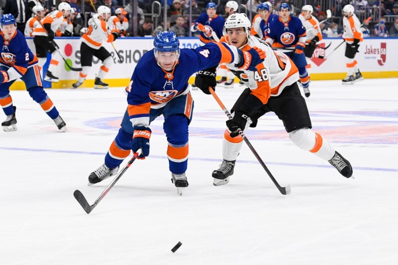 Jan 17, 2022; Elmont, New York, USA; New York Islanders defenseman Andy Greene (4) and Philadelphia Flyers center Morgan Frost (48) chase after the puck during the first period at UBS Arena. Mandatory Credit: Dennis Schneidler-USA TODAY Sports