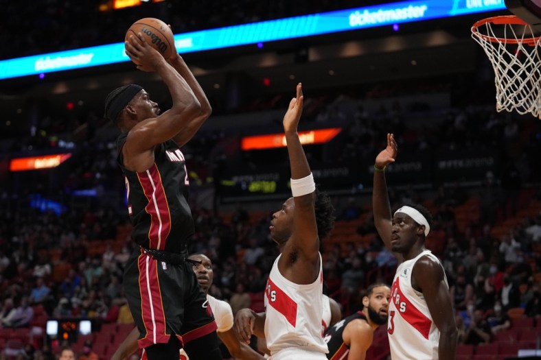 Jan 17, 2022; Miami, Florida, USA; Miami Heat forward Jimmy Butler (22) shoots the ball over Toronto Raptors forward OG Anunoby (3) and forward Pascal Siakam (43) during the first half at FTX Arena. Mandatory Credit: Jasen Vinlove-USA TODAY Sports