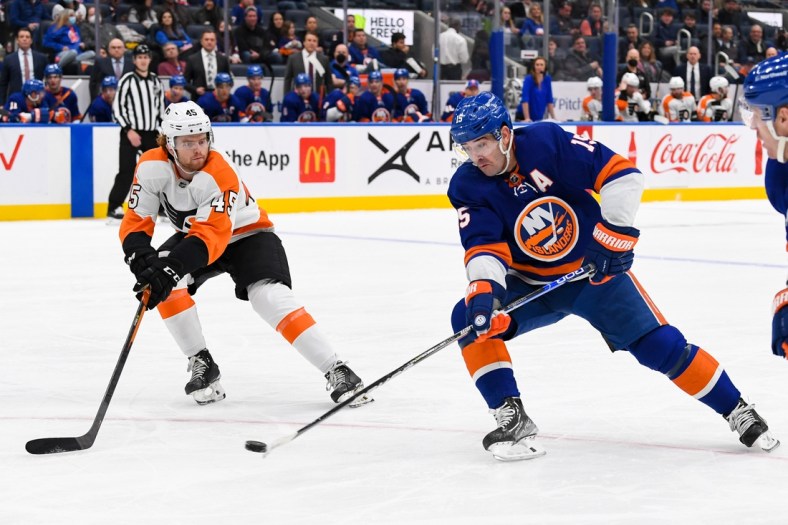 Jan 17, 2022; Elmont, New York, USA;  New York Islanders right wing Cal Clutterbuck (15) attempts a back hand shot defended by Philadelphia Flyers defenseman Cam York (45) during the second period at UBS Arena. Mandatory Credit: Dennis Schneidler-USA TODAY Sports