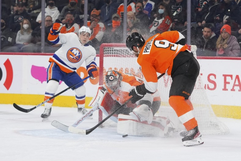 Jan 18, 2022; Philadelphia, Pennsylvania, USA; Philadelphia Flyers goaltender Carter Hart (79) covers up the puck in front of New York Islanders center Jean-Gabriel Pageau (44) and defenseman Ivan Provorov (9) in the first period at the Wells Fargo Center. Mandatory Credit: Mitchell Leff-USA TODAY Sports