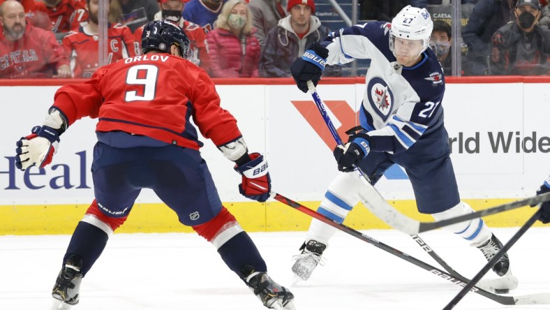 Jan 18, 2022; Washington, District of Columbia, USA; Winnipeg Jets left wing Nikolaj Ehlers (27) shoots the puck as Washington Capitals defenseman Dmitry Orlov (9) defends during the second period at Capital One Arena. Mandatory Credit: Geoff Burke-USA TODAY Sports