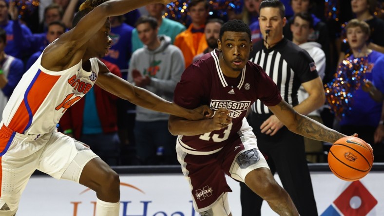 Jan 19, 2022; Gainesville, Florida, USA; Mississippi State Bulldogs forward D.J. Jeffries (13) drives to the basket as Florida Gators guard Kowacie Reeves (14) defends during the first half at Billy Donovan Court at Exactech Arena. Mandatory Credit: Kim Klement-USA TODAY Sports