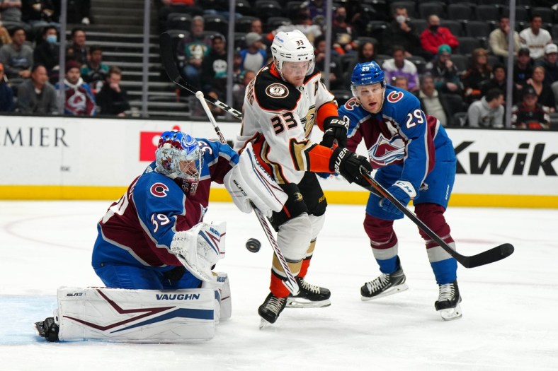 Jan 19, 2022; Anaheim, California, USA; Anaheim Ducks right wing Jakob Silfverberg (33) battles for the puck with Colorado Avalanche center Nathan MacKinnon (29) and goaltender Pavel Francouz (39) in the first period at Honda Center. Mandatory Credit: Kirby Lee-USA TODAY Sports