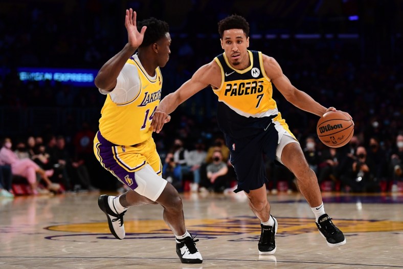 Jan 19, 2022; Los Angeles, California, USA; Indiana Pacers guard Malcolm Brogdon (7) moves the ball against Los Angeles Lakers forward Stanley Johnson (14) during the first half at Crypto.com Arena. Mandatory Credit: Gary A. Vasquez-USA TODAY Sports