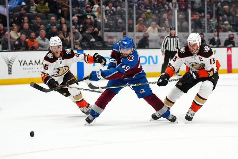 Jan 19, 2022; Anaheim, California, USA; Colorado Avalanche defenseman Samuel Girard (49) shoots the puck past Anaheim Ducks center Ryan Getzlaf (15) and center Trevor Zegras (46) for a goal in the second period at Honda Center. Mandatory Credit: Kirby Lee-USA TODAY Sports