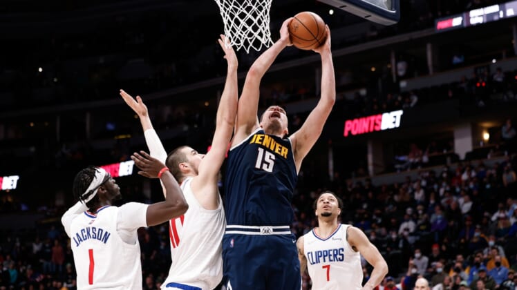 Jan 19, 2022; Denver, Colorado, USA; Denver Nuggets center Nikola Jokic (15) drives to the net against Los Angeles Clippers center Ivica Zubac (40) and guard Reggie Jackson (1) as guard Amir Coffey (7) defends in overtime at Ball Arena. Mandatory Credit: Isaiah J. Downing-USA TODAY Sports