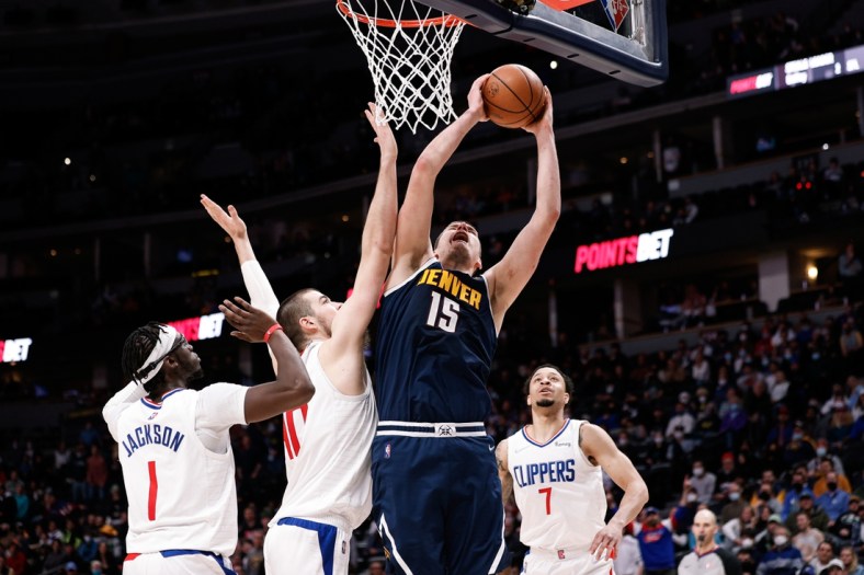 Jan 19, 2022; Denver, Colorado, USA; Denver Nuggets center Nikola Jokic (15) drives to the net against Los Angeles Clippers center Ivica Zubac (40) and guard Reggie Jackson (1) as guard Amir Coffey (7) defends in overtime at Ball Arena. Mandatory Credit: Isaiah J. Downing-USA TODAY Sports