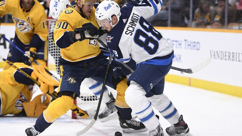 Jan 20, 2022; Nashville, Tennessee, USA;  Nashville Predators defenseman Mark Borowiecki (90) and Winnipeg Jets left wing Pierre-Luc Dubois (80) fight for the puck during the second period at Bridgestone Arena. Mandatory Credit: Steve Roberts-USA TODAY Sports