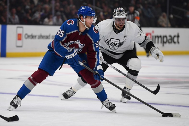 Jan 20, 2022; Los Angeles, California, USA; Colorado Avalanche left wing Andre Burakovsky (95) moves the puck ahead of Los Angeles Kings center Anze Kopitar (11) during the first period at Crypto.com Arena. Mandatory Credit: Gary A. Vasquez-USA TODAY Sports