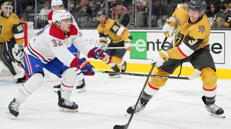 Jan 20, 2022; Las Vegas, Nevada, USA;Vegas Golden Knights defenseman Brayden McNabb (3) clears the puck against the slash of Montreal Canadiens center Rem Pitlick (32) during the first period at T-Mobile Arena. Mandatory Credit: Stephen R. Sylvanie-USA TODAY Sports
