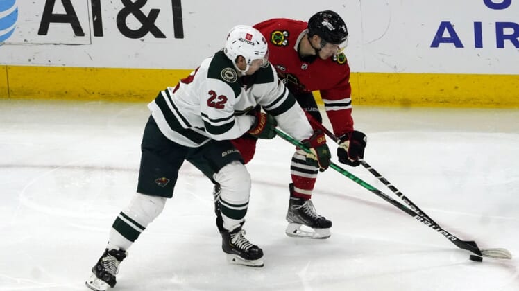 Jan 21, 2022; Chicago, Illinois, USA; Minnesota Wild left wing Kevin Fiala (22) and Chicago Blackhawks left wing Dominik Kubalik (8) go for the puck during the second period at United Center. Mandatory Credit: David Banks-USA TODAY Sports
