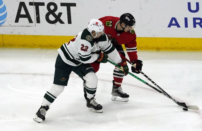 Jan 21, 2022; Chicago, Illinois, USA; Minnesota Wild left wing Kevin Fiala (22) and Chicago Blackhawks left wing Dominik Kubalik (8) go for the puck during the second period at United Center. Mandatory Credit: David Banks-USA TODAY Sports