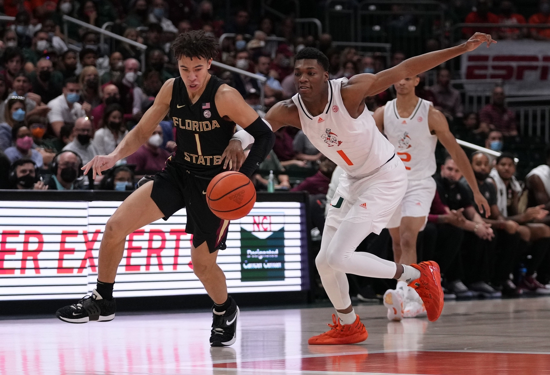 Jan 22, 2022; Coral Gables, Florida, USA; Florida State Seminoles guard Jalen Warley (1) and Miami Hurricanes forward Anthony Walker (1) chase a loose ball during the first half at Watsco Center. Mandatory Credit: Jasen Vinlove-USA TODAY Sports