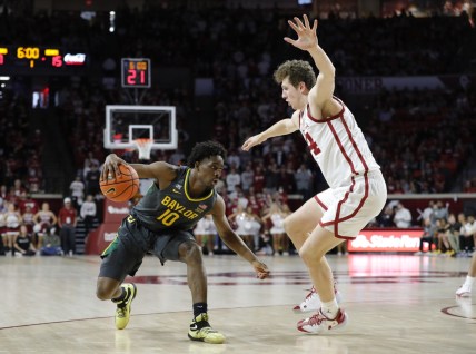Jan 22, 2022; Norman, Oklahoma, USA; Baylor Bears guard Adam Flagler (10) is defended by Oklahoma Sooners forward Jacob Groves (34) on a drive to the basket during the first half at Lloyd Noble Center. Mandatory Credit: Alonzo Adams-USA TODAY Sports