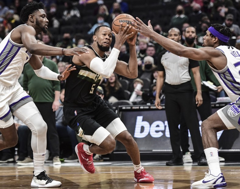 Jan 22, 2022; Milwaukee, Wisconsin, USA; Milwaukee Bucks guard Rodney Hood (5) drives to the basket against Sacramento Kings forward Chimezie Metu (left) and guard Buddy Hield (right) in the second quarter at Fiserv Forum. Mandatory Credit: Benny Sieu-USA TODAY Sports