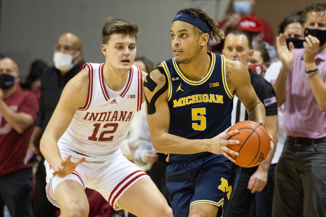 Jan 23, 2022; Bloomington, Indiana, USA; Michigan Wolverines forward Terrance Williams II (5) dribbles the ball while Indiana Hoosiers forward Miller Kopp (12) defends in the first half at Simon Skjodt Assembly Hall. Mandatory Credit: Trevor Ruszkowski-USA TODAY Sports