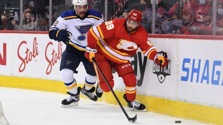 Jan 24, 2022; Calgary, Alberta, CAN; Calgary Flames forward Dillon Dube (29) battles for the puck with St. Louis Blues defenseman Justin Faulk (72) during the first period at Scotiabank Saddledome. Mandatory Credit: Candice Ward-USA TODAY Sports