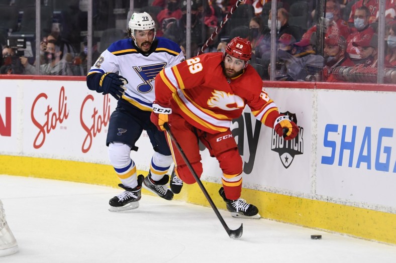 Jan 24, 2022; Calgary, Alberta, CAN; Calgary Flames forward Dillon Dube (29) battles for the puck with St. Louis Blues defenseman Justin Faulk (72) during the first period at Scotiabank Saddledome. Mandatory Credit: Candice Ward-USA TODAY Sports