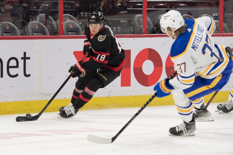 Jan 25, 2022; Ottawa, Ontario, CAN; Ottawa Senators left wing Tim St  tzle (18) skates with the puck in front of Buffalo Sabres center Casey Mittelstadt (37) in the first period at the Canadian Tire Centre. Mandatory Credit: Marc DesRosiers-USA TODAY Sports