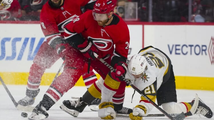 Jan 25, 2022; Raleigh, North Carolina, USA;  Carolina Hurricanes defenseman Ian Cole (28) battles over the puck against Vegas Golden Knights center Brett Howden (21) during the first period at PNC Arena. Mandatory Credit: James Guillory-USA TODAY Sports