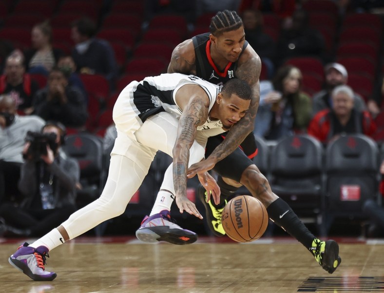 Jan 25, 2022; Houston, Texas, USA; San Antonio Spurs guard Dejounte Murray (5) and Houston Rockets guard Kevin Porter Jr. (3) battle for a loose ball during the first quarter at Toyota Center. Mandatory Credit: Troy Taormina-USA TODAY Sports
