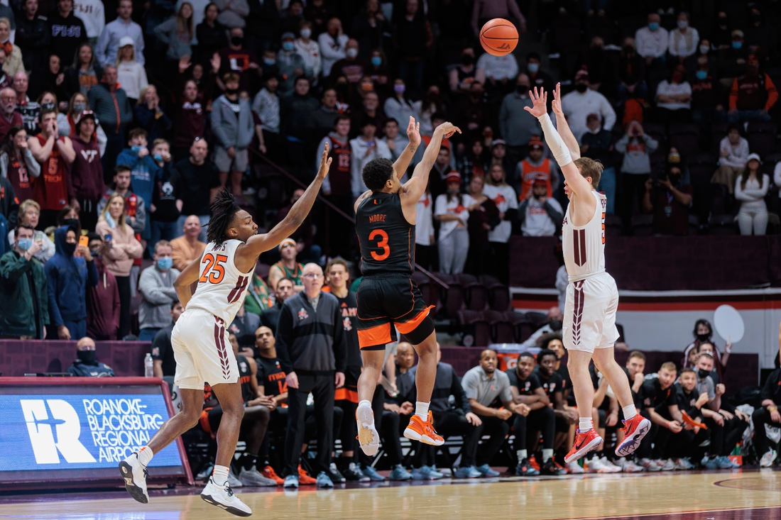 Jan 26, 2022; Blacksburg, Virginia, USA; Miami Hurricanes guard Charlie Moore (3) shoots a buzzer beater three-pointer over Virginia Tech Hokies guard Storm Murphy (5) during the second half at Cassell Coliseum. Mandatory Credit: Ryan Hunt-USA TODAY Sports