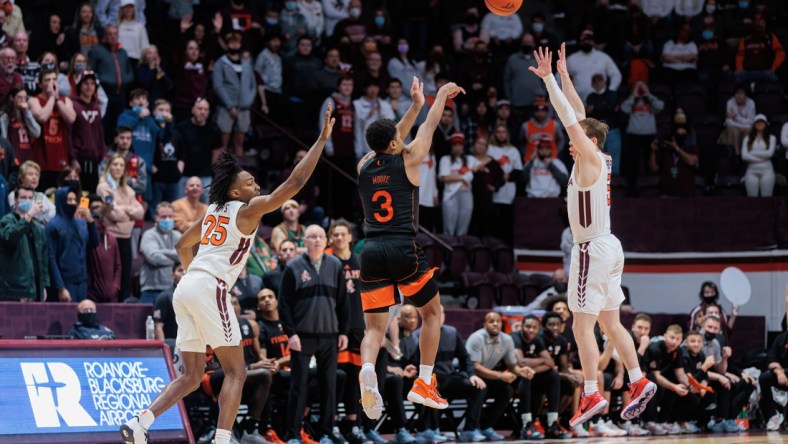 Jan 26, 2022; Blacksburg, Virginia, USA; Miami Hurricanes guard Charlie Moore (3) shoots a buzzer beater three-pointer over Virginia Tech Hokies guard Storm Murphy (5) during the second half at Cassell Coliseum. Mandatory Credit: Ryan Hunt-USA TODAY Sports