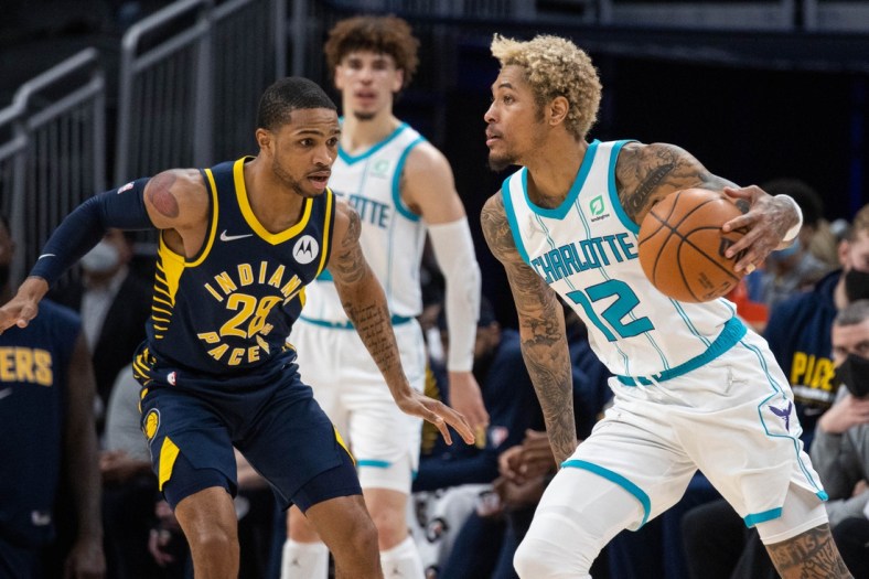 Jan 26, 2022; Indianapolis, Indiana, USA; Charlotte Hornets guard Kelly Oubre Jr. (12) dribbles the ball while Indiana Pacers guard Keifer Sykes (28) defends in the second half at Gainbridge Fieldhouse. Mandatory Credit: Trevor Ruszkowski-USA TODAY Sports