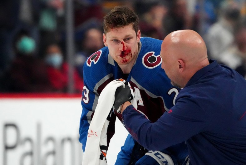 Jan 26, 2022; Denver, Colorado, USA; Colorado Avalanche center Nathan MacKinnon (29) is treated for an injury in the first period against the Boston Bruins at Ball Arena. Mandatory Credit: Ron Chenoy-USA TODAY Sports