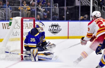 Jan 27, 2022; St. Louis, Missouri, USA;  St. Louis Blues goaltender Ville Husso (35) defends the net against Calgary Flames center Sean Monahan (23) during the first period at Enterprise Center. Mandatory Credit: Jeff Curry-USA TODAY Sports