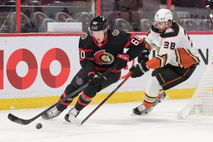 Jan 29, 2022; Ottawa, Ontario, CAN; Ottawa Senators defenseman Lassi Thomson (60) skates with the puck in front of Anaheim Ducks center Derek Grant (38) in the first period at the Canadian Tire Centre. Mandatory Credit: Marc DesRosiers-USA TODAY Sports