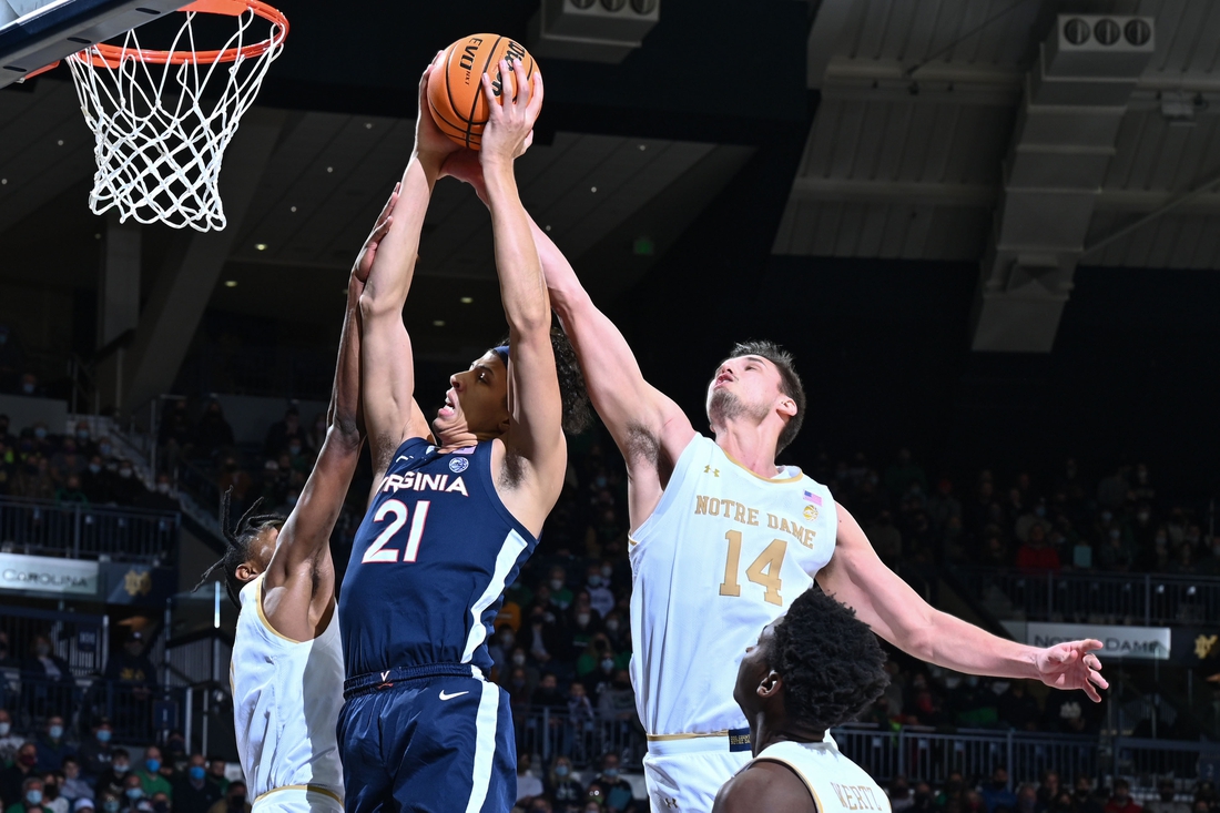 Jan 29, 2022; South Bend, Indiana, USA; Virginia Cavaliers forward Kadin Shedrick (21) and Notre Dame Fighting Irish forward Nate Laszewski (14) reach for a rebound in the first half at the Purcell Pavilion. Mandatory Credit: Matt Cashore-USA TODAY Sports