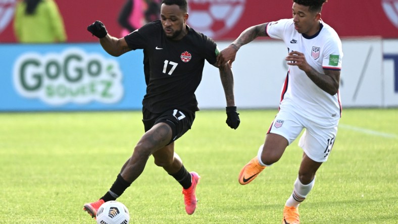 Jan 30, 2022; Hamilton, Ontario, CAN; Canada forward Cyle Larin (17) dribbles the ball away from United States defender Chris Richards (15) during a CONCACAF FIFA World Cup Qualifier soccer match at Tim Hortons Field. Mandatory Credit: Dan Hamilton-USA TODAY Sports