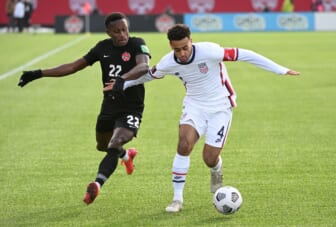 Jan 30, 2022; Hamilton, Ontario, CAN;   Canada defender Richie Laryea (22) battles for the ball with United States midfielder Tyler Adams (4) during a CONCACAF FIFA World Cup Qualifier soccer match at Tim Hortons Field. Mandatory Credit: Dan Hamilton-USA TODAY Sports