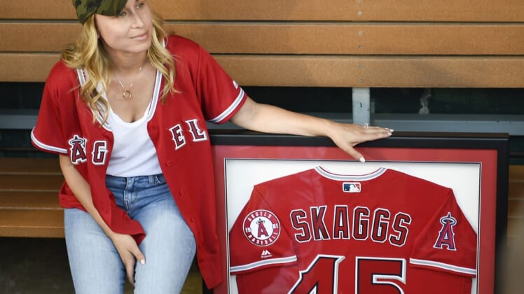 Jul 12, 2019; Anaheim, CA, USA; Wife of Los Angeles Angels starting pitcher Tyler Skaggs (45) Carli Skaggs sits next to a framed jersey for her husband prior to the game against the Seattle Mariners at Angel Stadium of Anaheim. Mandatory Credit: Kelvin Kuo-USA TODAY Sports