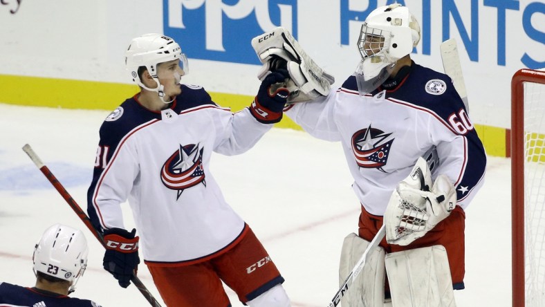 Sep 27, 2021; Pittsburgh, Pennsylvania, USA; Columbus Blue Jackets defenseman Stanislav Svozil (81) congratulates goalie Jet Greaves (60) after the Blue Jackets shutout the Pittsburgh Penguins 3-0 at PPG Paints Arena. Mandatory Credit: Charles LeClaire-USA TODAY Sports