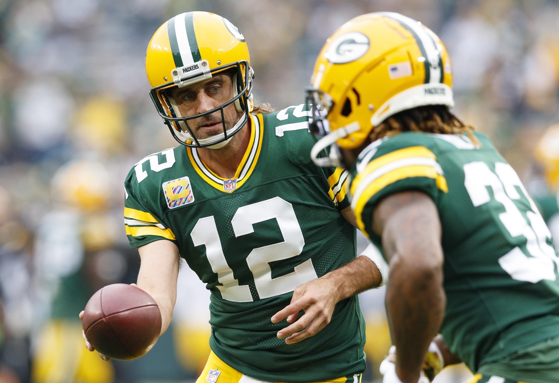 Oct 3, 2021; Green Bay, Wisconsin, USA;  Green Bay Packers quarterback Aaron Rodgers (12) hands the football off to running back Aaron Jones (33) during warmups prior to the game against the Pittsburgh Steelers at Lambeau Field. Mandatory Credit: Jeff Hanisch-USA TODAY Sports