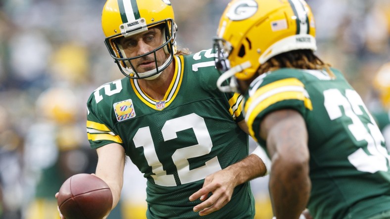 Oct 3, 2021; Green Bay, Wisconsin, USA;  Green Bay Packers quarterback Aaron Rodgers (12) hands the football off to running back Aaron Jones (33) during warmups prior to the game against the Pittsburgh Steelers at Lambeau Field. Mandatory Credit: Jeff Hanisch-USA TODAY Sports