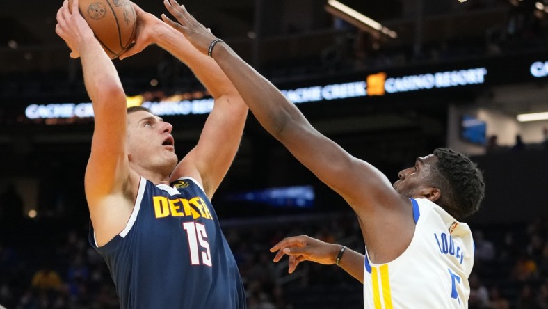 October 6, 2021; San Francisco, California, USA; Denver Nuggets center Nikola Jokic (15) shoots the basketball against Golden State Warriors center Kevon Looney (5) during the first quarter at Chase Center. Mandatory Credit: Kyle Terada-USA TODAY Sports