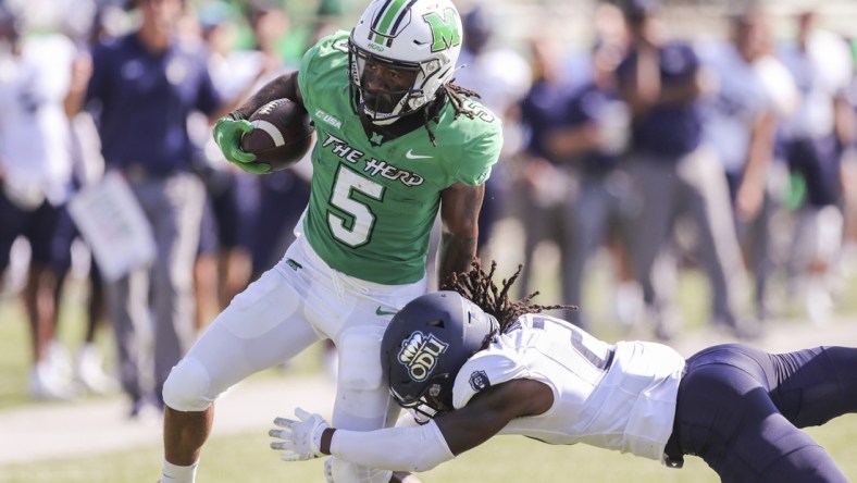 Oct 9, 2021; Huntington, West Virginia, USA; Marshall Thundering Herd running back Sheldon Evans (5) runs the ball and shakes a tackle from Old Dominion Monarchs safety R'Tarriun Johnson (21) during the second quarter at Joan C. Edwards Stadium. Mandatory Credit: Ben Queen-USA TODAY Sports