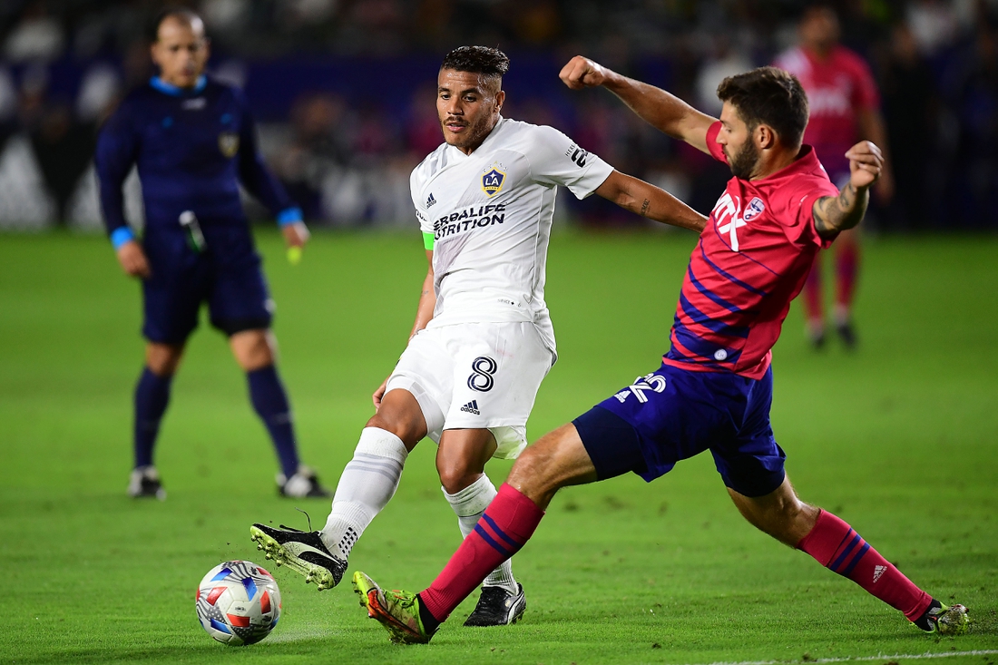 Oct 23, 2021; Carson, California, USA; Los Angeles Galaxy midfielder Jonathan dos Santos (8) moves the ball against FC Dallas midfielder Ryan Hollingshead (12) during the first half at StubHub Center. Mandatory Credit: Gary A. Vasquez-USA TODAY Sports