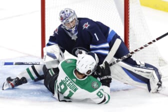 Nov 2, 2021; Winnipeg, Manitoba, CAN;  Dallas Stars center Tyler Seguin (91) collides with Winnipeg Jets goaltender Eric Comrie (1) in the third period at Canada Life Centre. Mandatory Credit: James Carey Lauder-USA TODAY Sports