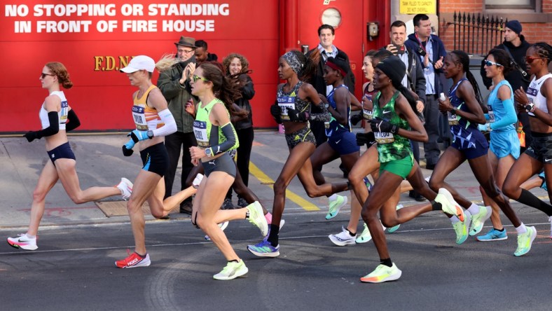 Nov 7, 2021; New York, New York, USA;  Elite runners go by a fire house in Brooklyn during the New York City Marathon.  Mandatory Credit: Kevin R. Wexler-USA TODAY Sports