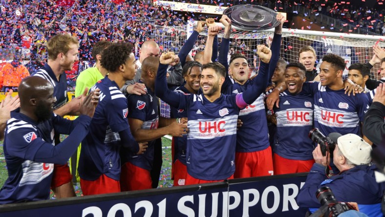 Nov 7, 2021; Foxborough, Massachusetts, USA; New England Revolution forward Gustavo Bou (7) and New England Revolution midfielder Carles Gil (22) celebrate winning the 2021 Supporters  Shield at Gillette Stadium. Mandatory Credit: Paul Rutherford-USA TODAY Sports