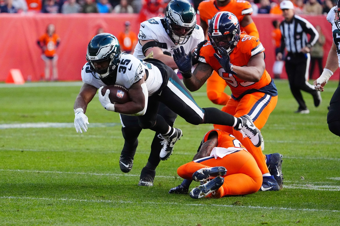 Nov 14, 2021; Denver, Colorado, USA; Philadelphia Eagles running back Boston Scott (35) dives over Denver Broncos safety Kareem Jackson (22) in the first quarter at Empower Field at Mile High. Mandatory Credit: Ron Chenoy-USA TODAY Sports