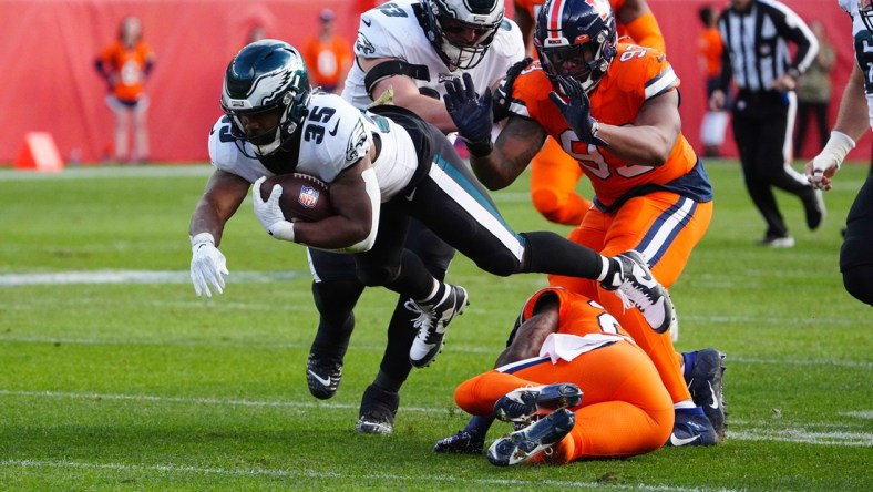 Nov 14, 2021; Denver, Colorado, USA; Philadelphia Eagles running back Boston Scott (35) dives over Denver Broncos safety Kareem Jackson (22) in the first quarter at Empower Field at Mile High. Mandatory Credit: Ron Chenoy-USA TODAY Sports