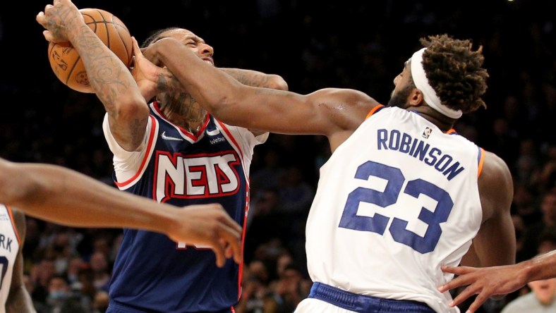 Nov 30, 2021; Brooklyn, New York, USA; Brooklyn Nets forward James Johnson (16) is fouled as he drives to the basket by New York Knicks center Mitchell Robinson (23) during the fourth quarter at Barclays Center. Mandatory Credit: Brad Penner-USA TODAY Sports