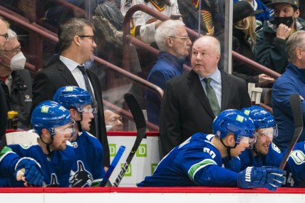 Dec 6, 2021; Vancouver, British Columbia, CAN; Vancouver assistant coach Scott Walker and head coach Bruce Boudreau on the bench during a game against the Los Angeles Kings in the first period at Rogers Arena. Mandatory Credit: Bob Frid-USA TODAY Sports